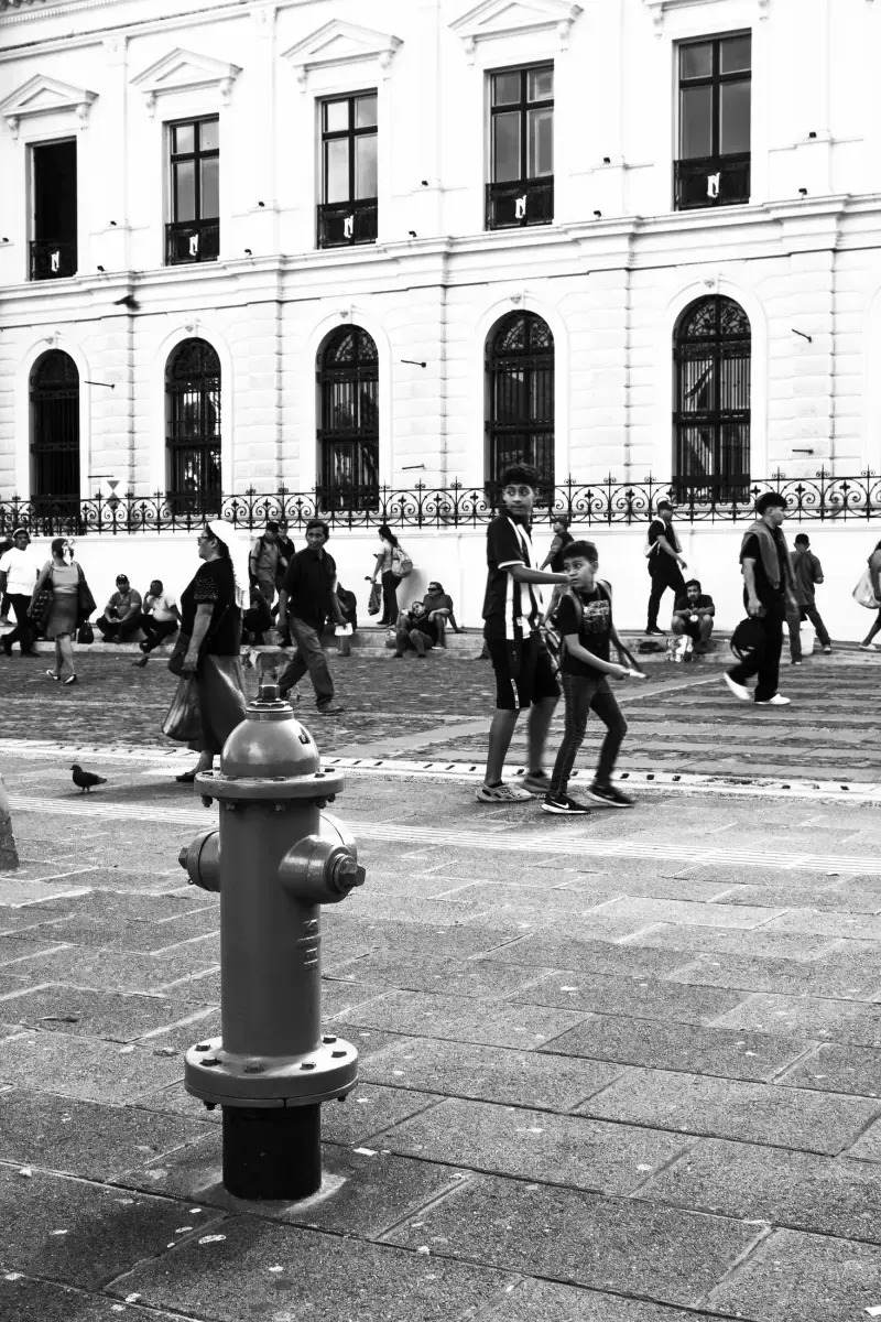 Hidrante en primer plano frente a una plaza y edificio clásico